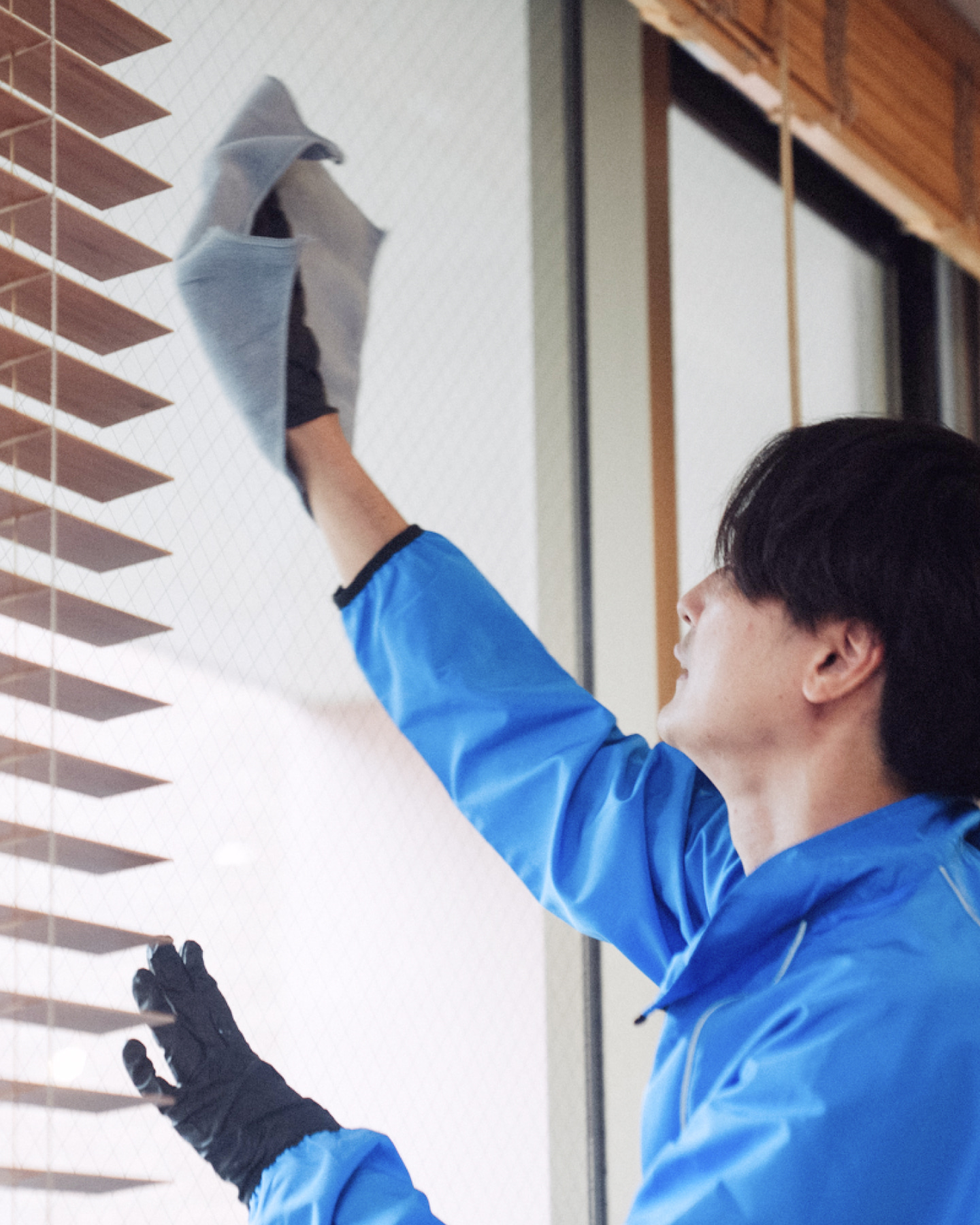 腕を組んで笑顔で立つ作業着姿の男性