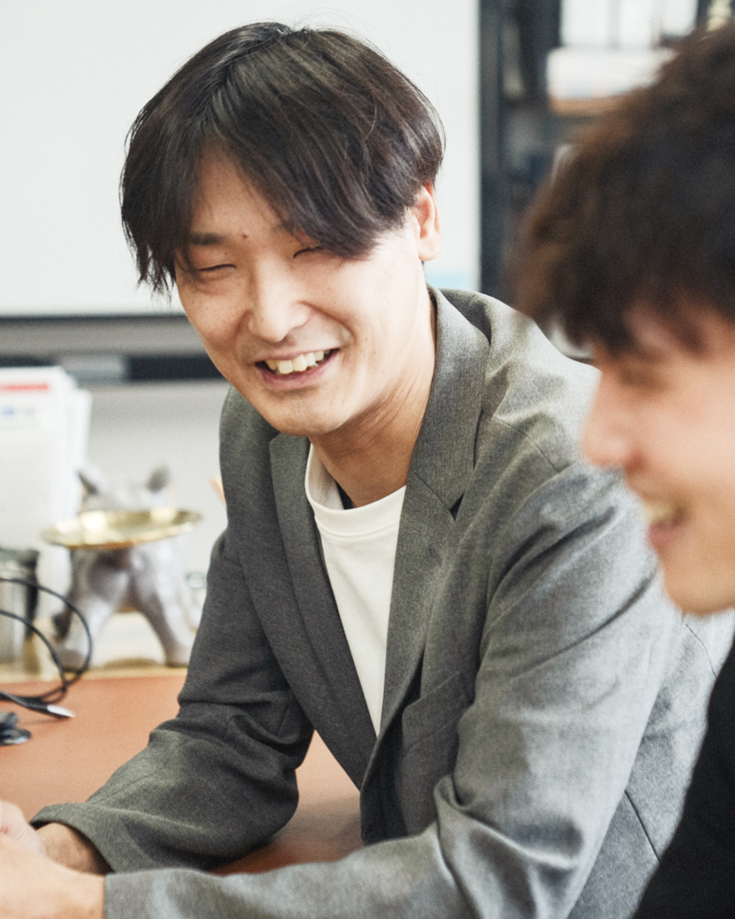 腕を組んで笑顔で立つ作業着姿の男性