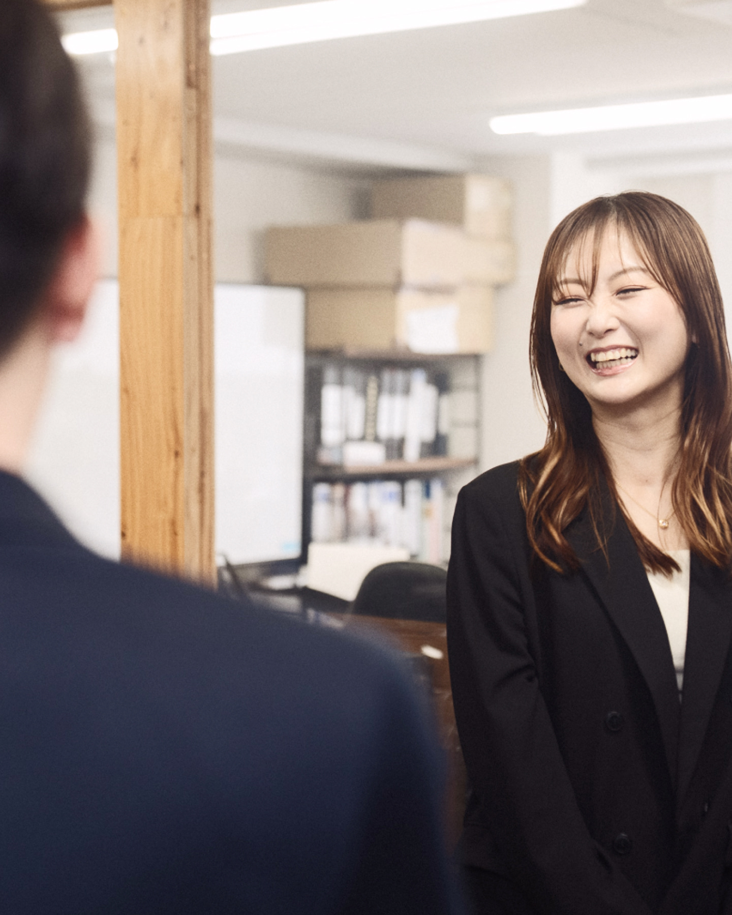 腕を組んで笑顔で立つ作業着姿の男性