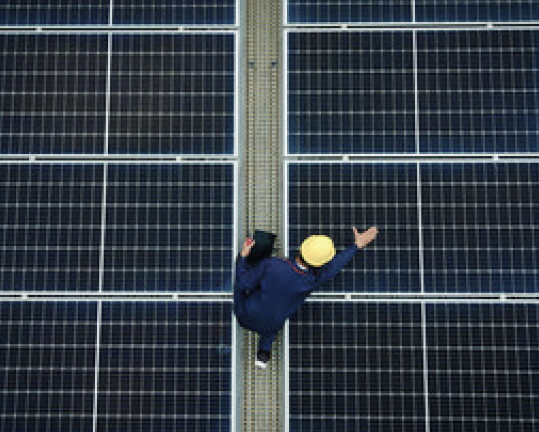 ソーラーパネルを点検する作業員の写真
