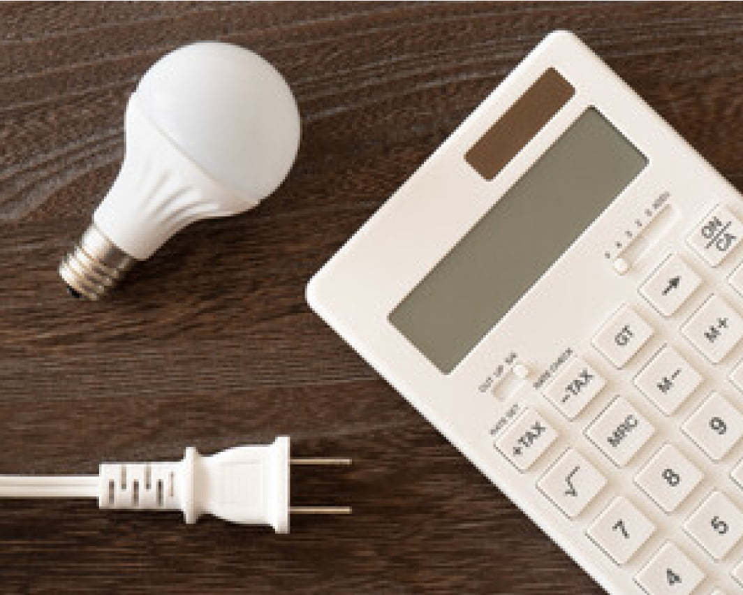 電卓と電球が並ぶテーブルの様子の写真