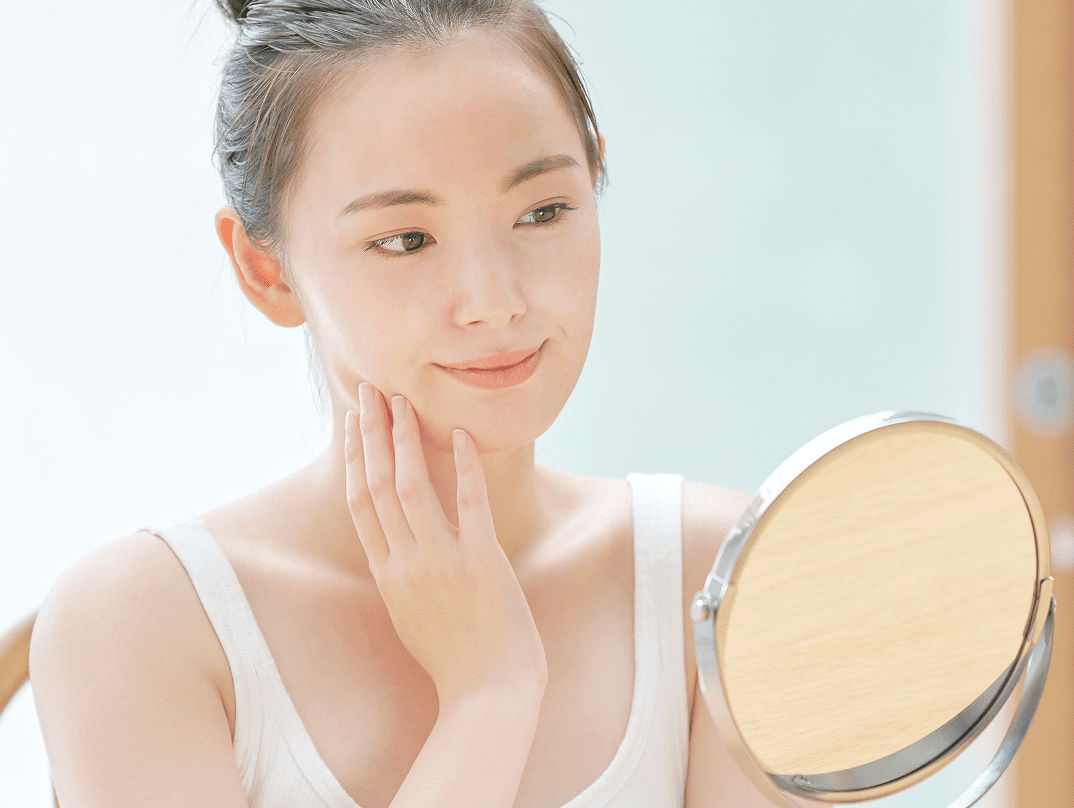 鏡を見る美肌女性の写真